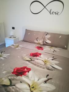 a bed with white and red flowers on it at Casa Marietta in Polignano a Mare