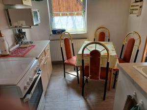 uma cozinha com mesa e cadeiras e um balcão em Ferienwohnung em Reinhardtsdorf