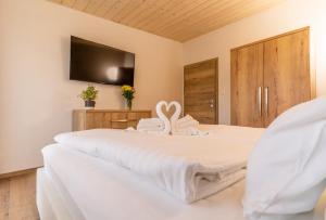 a bedroom with a bed with a tv on the wall at Villa Gloria Rooms & Apartments in Donovaly