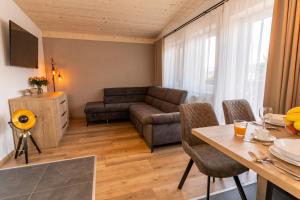 ein Wohnzimmer mit einem Tisch und einem Sofa in der Unterkunft Villa Gloria Rooms & Apartments in Donovaly