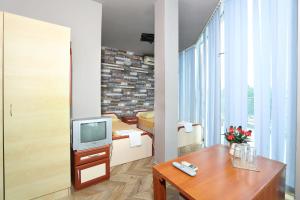a living room with a tv and a table at La Piazza Family Hotel in Sunny Beach