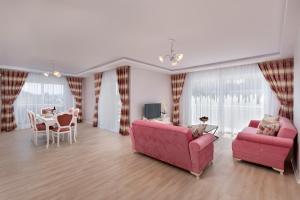 a living room with two pink couches and a table at Onix Apart Hotel in Antalya