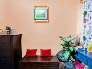 sala de estar con cofre de madera y almohadas rojas en OYO 90234 Dhoho Family Guest House, en Kediri