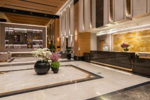 a lobby with two vases with flowers on the floor at Gardino Hotel & Residence in Riyadh