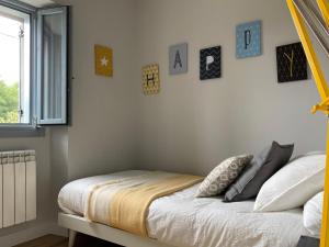 - un lit dans une chambre avec des photos sur le mur dans l'établissement Adosado La Concha, à Llanes