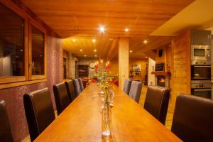 a long wooden table in a room with chairs at Chalet Sophia by Chalet Chardons in Tignes