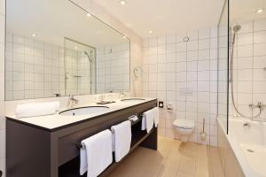 a bathroom with a tub, toilet and sink at Tivoli Hotel Innsbruck in Innsbruck