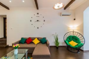 a living room with a couch and a clock on the wall at 2к квартира біля Оперного театру, метро Золоті Ворота in Kyiv