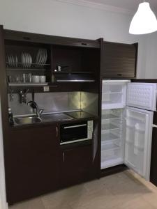 a kitchen with a sink and an open refrigerator at Metamorfosis Apartments in Metamorfosi