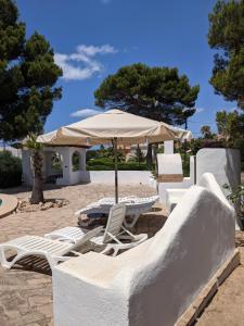 un grupo de sillas y una sombrilla en una playa en Villa Vivaldi 100m sea & panoramic sea view, en Cala Pi