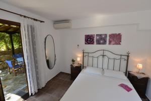 a bedroom with a large bed and a balcony at Haus Katerina in Vourvourou