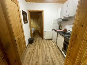 cocina pequeña con fregadero y suelo de madera en Haus im Grünen, en Trendelburg