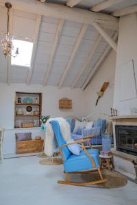 Casa Leandra con jacuzzi في أديخي: غرفة معيشة مع كرسي أزرق ومدفأة