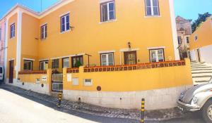 una casa gialla con una macchina parcheggiata di fronte di Casa Mathilde Sintra a Sintra