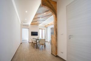 a hallway with a table and chairs in a room at Mola’s Square House in Mola di Bari