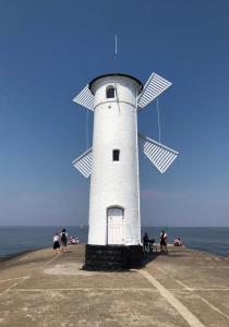 a white windmill sitting on top of a pier at Villa 44 - Studio Deluxe mit Balkon in Świnoujście