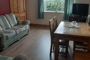 ein Wohnzimmer mit einem Tisch und einem Sofa in der Unterkunft Innishmore Island Farmhouse in Cavan