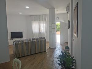 ein Wohnzimmer mit einem Sofa und einem TV in der Unterkunft Apartamentos Sanlúcar Beach 4 y 5 in Sanlúcar de Barrameda