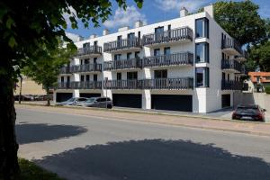 レバルにあるApartamenty Gryf Rewalの通りに面した白いアパートメントで、バルコニーが付いています。