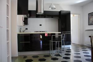 una cucina con armadi neri e pavimento a scacchi di Melograni 28 a Omegna