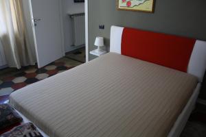 un letto con materasso rosso e bianco in una camera di Melograni 28 a Omegna