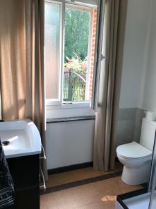 baño con aseo y lavabo y ventana en chambres d'hôtes et Gîte Le Moulin Sainte Marie, en Estrée-Wamin