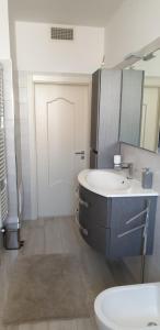 a bathroom with a sink and a toilet and a mirror at casa vacanze COL.MAR. in Turi