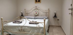 a bedroom with a metal bed with pillows on it at casa vacanze COL.MAR. in Turi