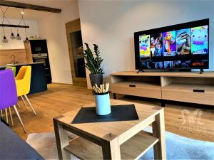 a living room with a tv and a coffee table at Arietem-Apartment in Gröbming
