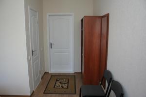 um quarto com uma porta, uma cadeira e um tapete em Hotel Aleksandria em Kharkov