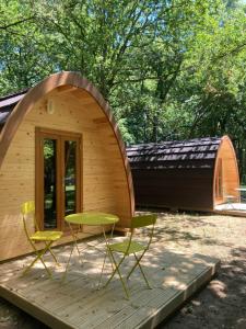 una piccola cabina in legno con tavolo e sedie su una terrazza di Camping Vila de Sarria a Sarria