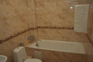a bathroom with a tub and a toilet and a sink at Hotel Aleksandria in Kharkiv