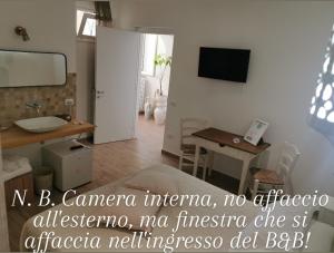 a room with a bathroom with a sink and a mirror at Vento d'aMare in Leporano