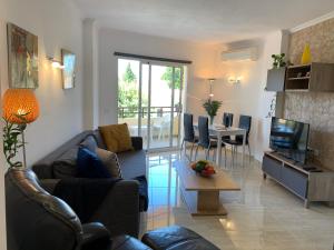 sala de estar con sofá, TV y mesa en Apartment Duquesa de España en Torremolinos