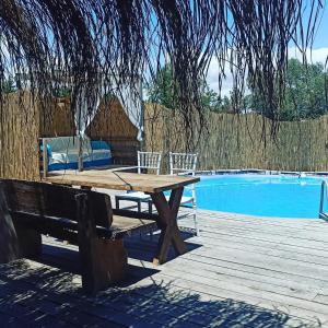 a wooden picnic table next to a swimming pool at Mylasa Farm and Villas in Muğla