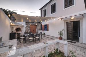 a patio with a table and chairs and a building at Kuća za odmor Tonka in Grižane