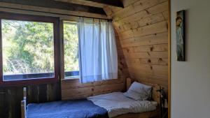 ein kleines Zimmer mit einem Bett und einem Fenster in der Unterkunft Bajeczka nad Sanem in Dwernik