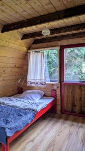 Posto letto in camera in legno con finestra. di Bajeczka a Dwernik