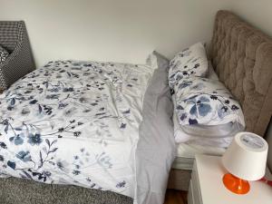 an unmade bed with blue and white sheets on it at Adorable Guest house in Erith