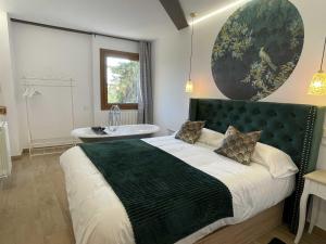 1 dormitorio con 1 cama grande y bañera en El Bulín de Montejo, en Montejo de la Sierra