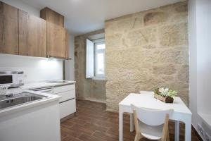 een keuken met een witte tafel met stoelen en een aanrecht bij Solar Valadim - serviced apartments in Castelo Branco