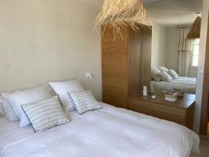 1 dormitorio con 1 cama blanca y 2 almohadas en Lostane - Villa sur le toit, en Grimaud