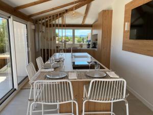 comedor con mesa y sillas blancas en Lostane - Villa sur le toit, en Grimaud