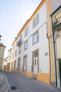 un edificio blanco con adornos naranjas en una calle en Solar Valadim - serviced apartments, en Castelo Branco