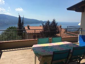 einen Tisch und Stühle auf einem Balkon mit Blick auf das Wasser in der Unterkunft Ferienwohnung Oleandro mit Panorama in Tignale am Gardasee in Tignale