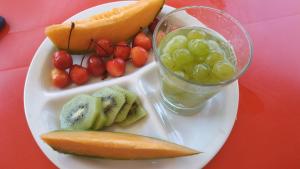 a plate of fruit and a drink on a table at Villaggio Camping Nurral in Fertilia