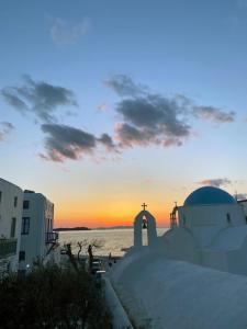 una chiesa con un tramonto sullo sfondo di M Residence Little Venice a Mykonos Città