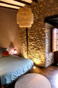 a bedroom with a bed and a stone wall at VELASCO JAUREGIA-SIERRA DE SUEÑOS in Orduña