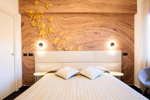 a bedroom with a white bed with a wooden wall at Bellevue - Rooms & Suites in Levanto