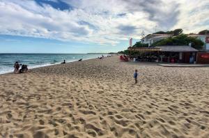 - un enfant debout sur une plage de sable près de l'océan dans l'établissement Apartamento a 300 mts de la playa, 25 minutos de Port Aventura y 50 de Barcelona, à Coma-ruga